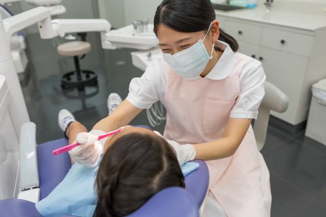 笑顔でフッ素塗布する歯科衛生士